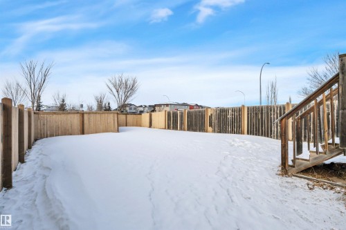 Yard covered in snow with a fenced backyard - 457 Aster Close, Leduc, AB - Outdoor