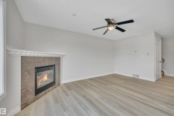 Unfurnished living room featuring a fireplace, light wood finished floors, and ceiling fan - 