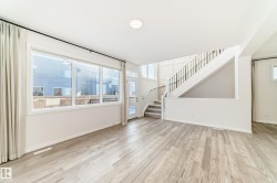 Unfurnished living room with stairway and light wood-style floors - 