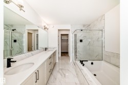 Bathroom with a walk in closet, a marble finish shower, double vanity, light marble finish floors, and a bath - 