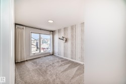 Empty room with light carpet and wallpapered walls - 