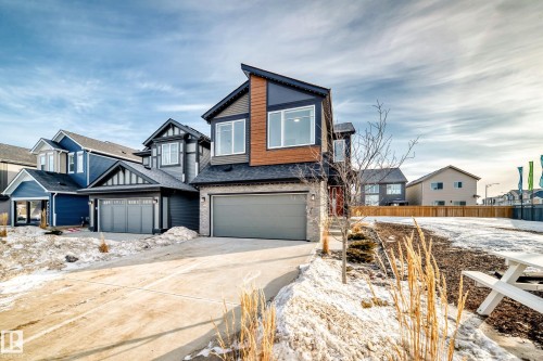 View of front facade featuring driveway, an attached garage, a residential view, and a shingled roof - 3249 Dixon Way, Edmonton, AB - Outdoor With Facade