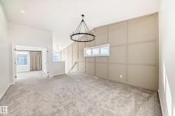 Unfurnished dining area featuring a decorative wall, light carpet, and a chandelier - 