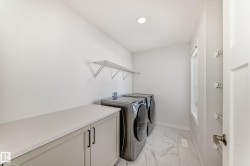 Laundry room with light marble finish floors and separate washer and dryer - 