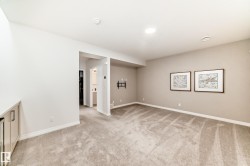 Spare room featuring light carpet and baseboards - 
