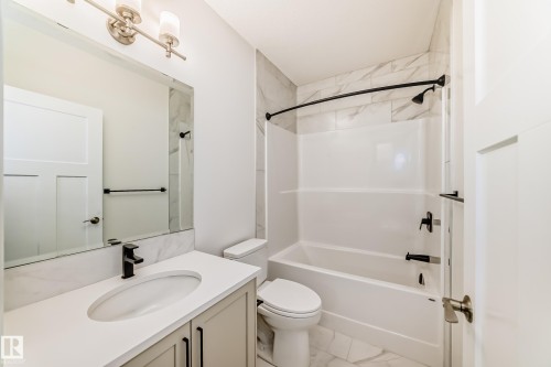 Bathroom featuring vanity, tub / shower combination, and light marble finish floors - 3249 Dixon Way, Edmonton, AB - Indoor Photo Showing Bathroom