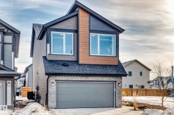 View of front of home featuring a garage, stone siding, a shingled roof, and concrete driveway - 