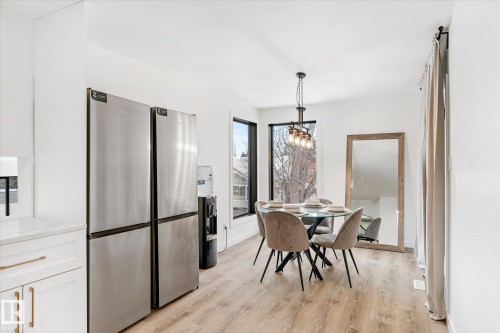 Dining area with light wood-style flooring and a chandelier - 38 Woodcrest Avenue, St. Albert, AB - Indoor Photo Showing Dining Room