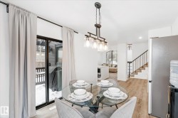 Dining room featuring light wood-style flooring, stairway, and plenty of natural light - 