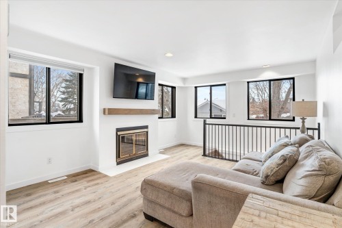 Living area with light wood-style floors, recessed lighting, and a fireplace with flush hearth - 38 Woodcrest Avenue, St. Albert, AB - Indoor Photo Showing Living Room With Fireplace