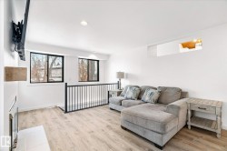 Living area with recessed lighting, light wood finished floors, and a fireplace - 