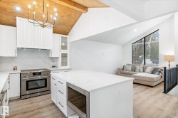 Kitchen featuring white cabinets, stainless steel appliances, a center island, light wood-style flooring, and recessed lighting - 