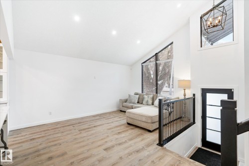 Sitting room with light wood-style flooring, high vaulted ceiling, and a chandelier - 38 Woodcrest Avenue, St. Albert, AB - Indoor