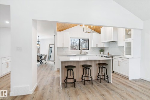 Kitchen featuring lofted ceiling, a breakfast bar, a center island, pendant lighting, and white cabinets - 38 Woodcrest Avenue, St. Albert, AB - Indoor Photo Showing Kitchen With Upgraded Kitchen