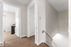 Hall featuring an upstairs landing and carpet floors - 
