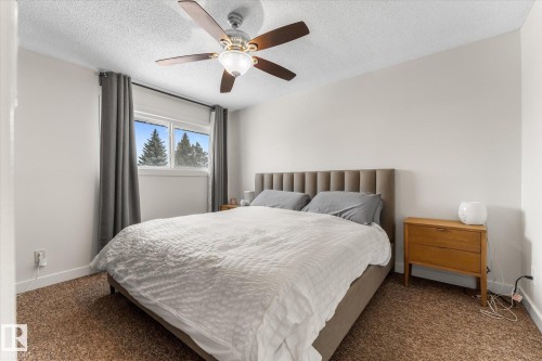 Carpeted bedroom with ceiling fan and a textured ceiling - 289 Grandin Village, St. Albert, AB - Indoor Photo Showing Bedroom