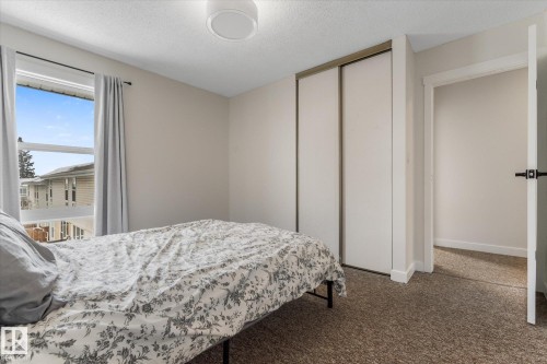 Carpeted bedroom with a textured ceiling and a closet - 289 Grandin Village, St. Albert, AB - Indoor Photo Showing Bedroom