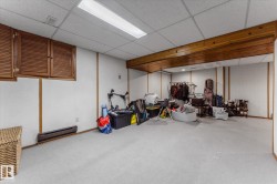 Finished below grade area featuring a paneled ceiling and a baseboard radiator - 