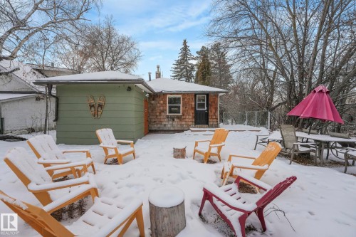 Snow covered patio with outdoor dining area and a deck - 5043 48 St, Sylvan Lake, AB - Outdoor With Deck Patio Veranda
