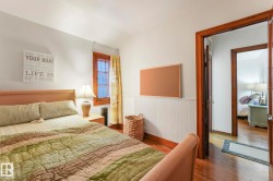 Bedroom with wood finished floors, wainscoting, and vaulted ceiling - 