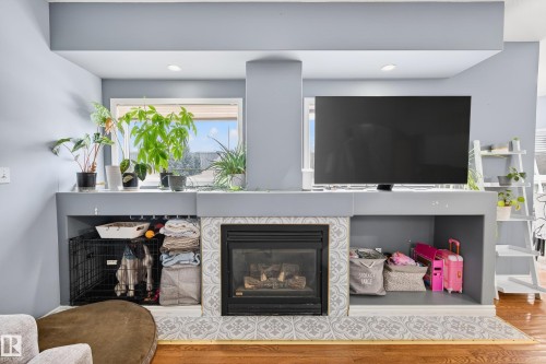 Detailed view of a tile fireplace and wood finished floors - 24 Olmstead Court, St. Albert, AB - Indoor Photo Showing Living Room With Fireplace