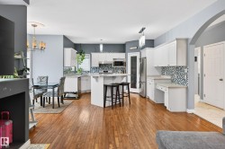 Kitchen featuring light countertops, light wood finished floors, arched walkways, and a breakfast bar area - 
