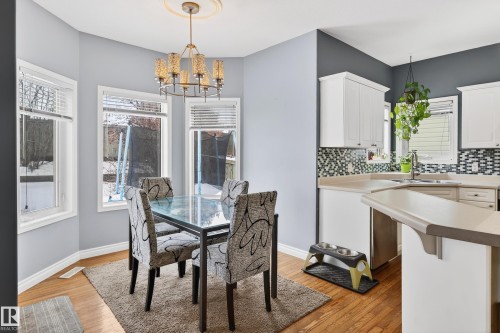 Dining room with light wood-style flooring and a chandelier - 24 Olmstead Court, St. Albert, AB - Indoor Photo Showing Dining Room