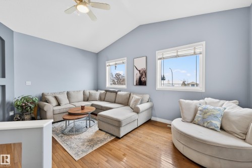 Living area with light wood-style flooring, vaulted ceiling, and ceiling fan - 24 Olmstead Court, St. Albert, AB - Indoor Photo Showing Living Room
