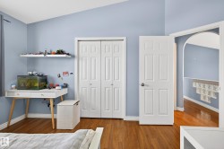 Bedroom featuring arched walkways, a closet, and wood finished floors - 