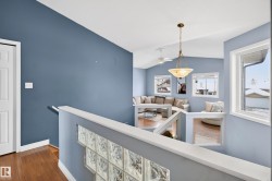 Hall with an upstairs landing, lofted ceiling, and dark wood-type flooring - 