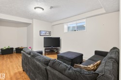 Living area with a textured ceiling and light wood-style flooring - 