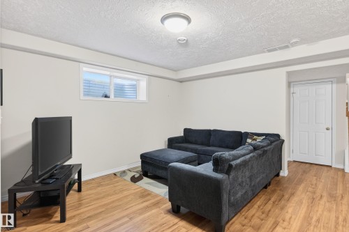 Living room featuring a textured ceiling and light wood-type flooring - 24 Olmstead Court, St. Albert, AB - Indoor