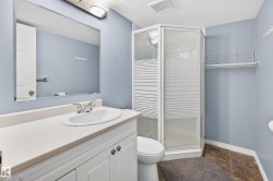 Bathroom featuring a shower stall and vanity - 