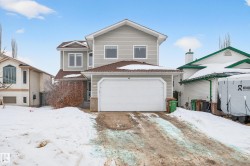 View of front facade featuring brick siding, driveway, and a garage - 