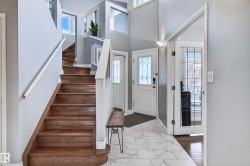 Foyer entrance with stairway, dark marble finish floors, and a high ceiling - 
