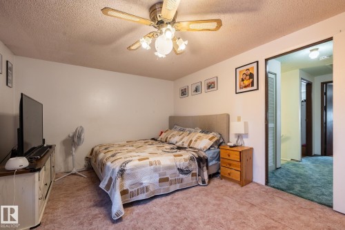 Bedroom featuring a textured ceiling, light colored carpet, and ceiling fan - 1346 Lakewood Road W, Edmonton, AB - Indoor Photo Showing Bedroom