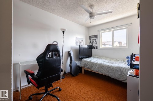 Bedroom featuring carpet floors, a textured ceiling, and a ceiling fan - 1346 Lakewood Road W, Edmonton, AB - Indoor Photo Showing Bedroom