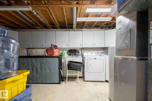 Unfinished below grade area with light floors, heating unit, and washing machine and dryer - 1346 Lakewood Road W, Edmonton, AB - Indoor Photo Showing Laundry Room