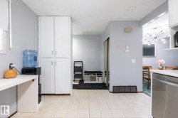 Kitchen featuring dishwasher, white cabinetry, and light countertops - 