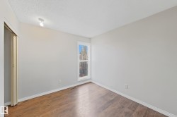Spare room featuring a textured ceiling and wood finished floors - 