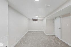 Finished below grade area featuring light carpet and baseboards - 