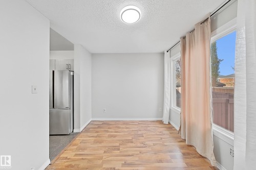 Unfurnished room with light wood finished floors and a textured ceiling - 24 3812 20 Avenue, Edmonton, AB - Indoor Photo Showing Other Room