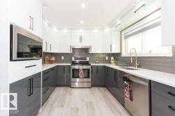 Kitchen featuring white cabinets, stainless steel appliances, light wood finished floors, modern cabinets, and gray cabinetry - 