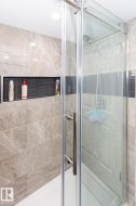 Bathroom featuring a shower stall and a textured ceiling - 