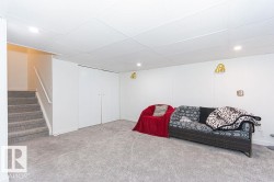 Living area featuring carpet, stairway, a drop ceiling, and recessed lighting - 