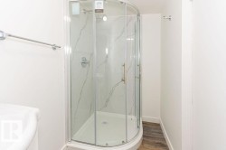 Full bath with a marble finish shower and wood finished floors - 