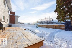 Yard covered in snow with a fenced backyard and a deck - 