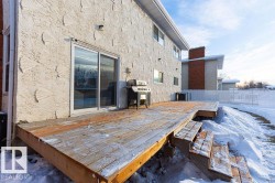 Snow covered patio featuring a grill and a deck - 