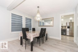 Dining space featuring light wood-style floors, a chandelier, and a textured ceiling - 