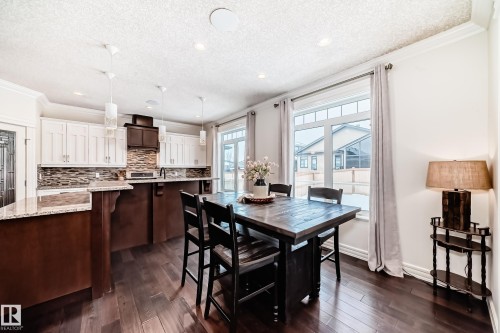 Dining space with crown molding, dark wood-style flooring, recessed lighting, and a textured ceiling - 6 Wade Avenue, Leduc, AB - Indoor